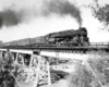 Steam locomotive with passenger train on steel viaduct