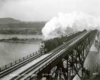Steam locomotive with train on deck truss bridge