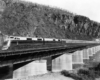 Streamlined diesel passenger train on deck girder bridge