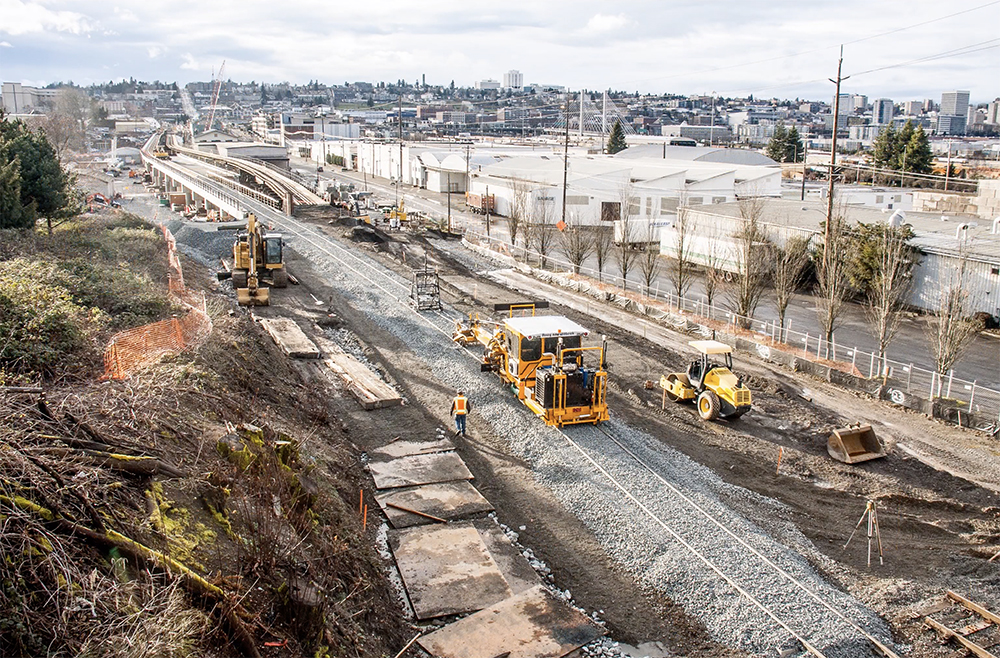 Yellow track maintenance equipment on a section of newly ballasted track.