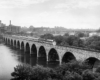 Streamlined passenger train on stone arch bridge