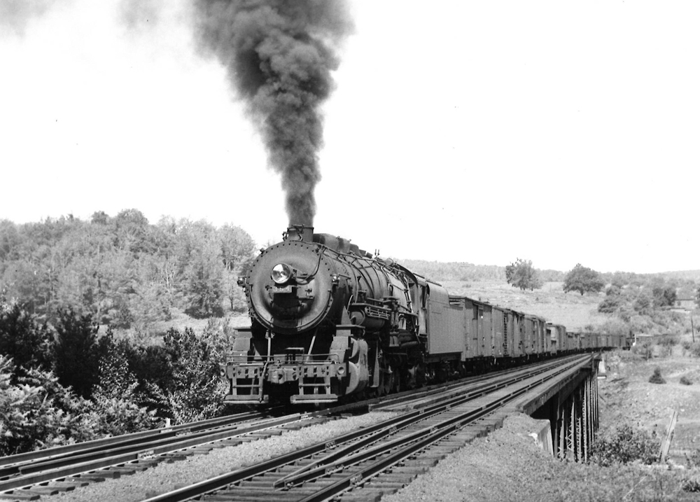 Steam locomotive with freight train crossing bridge