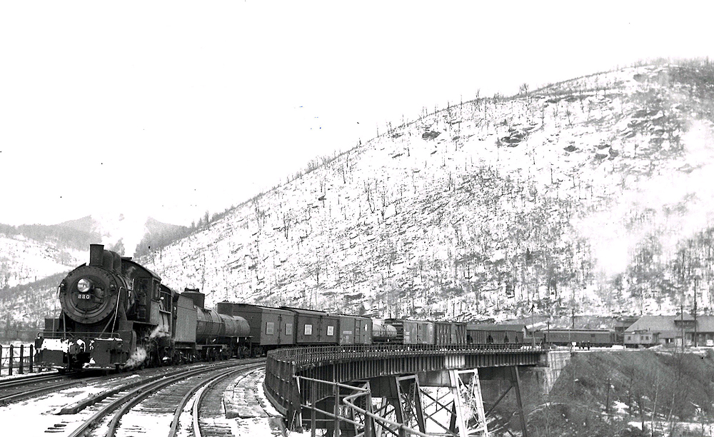 Steam locomotive with freight train on curved trestle