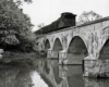 Caboose with freight train on concrete arch bridge