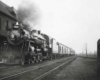 a steam engine pulling passenger cars