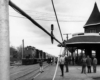 people waiting to board a passenger train at a station