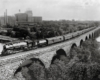 Steam powered passenger train on stone arch bridge