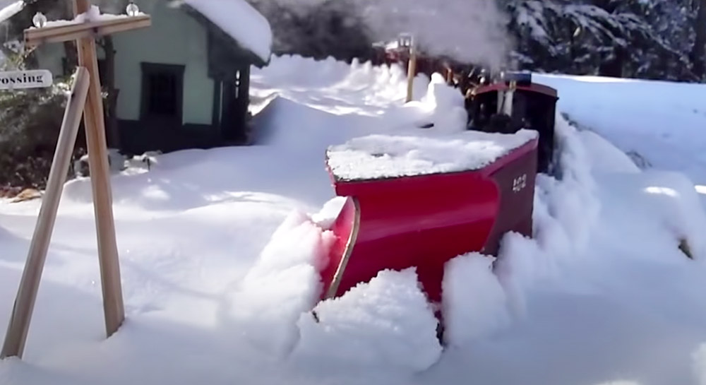 plow being pushed by model train to clear snow on a garden railroad