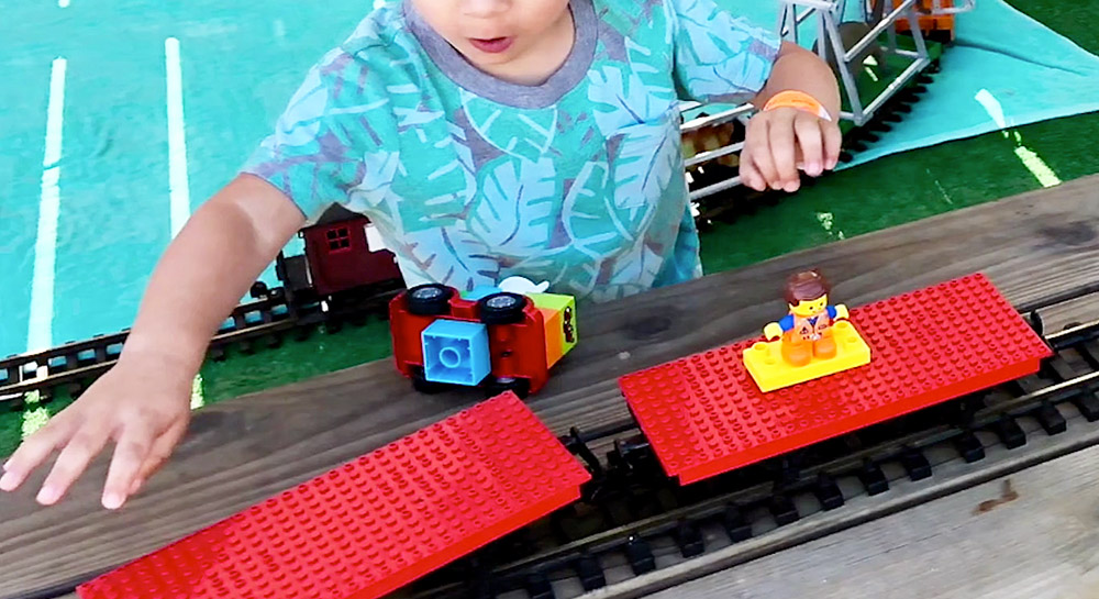 boy playing with a Lego train