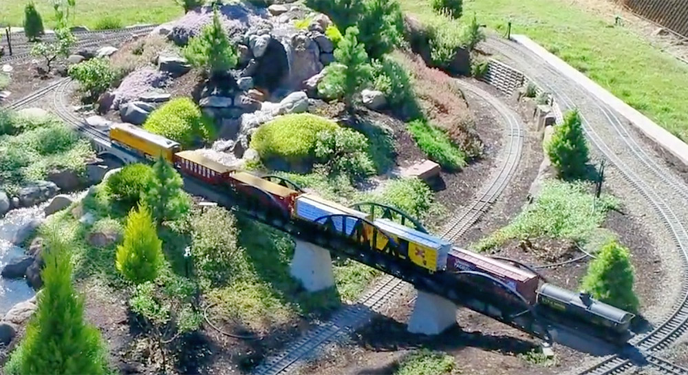 model train crossing a bridge on a garden railway