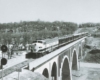 Diesel powered passenger train on concrete arch bridge