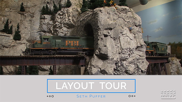 model train on bridge with rocky scenery