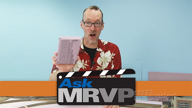 David Popp wearing a Hawaiian shirt and holding up a small piece of foam board.