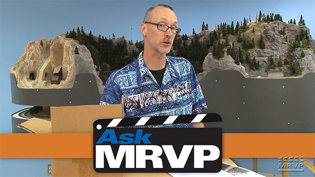 David Popp wearing a Hawaiian shirt and standing in front of the N scale Canadian Canyons layout.