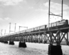 Electric-powered passenger train on deck truss bridge