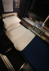 a bed in a roomette of a sleeping car