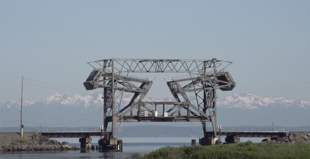 Coastal lift bridge mountains in background.