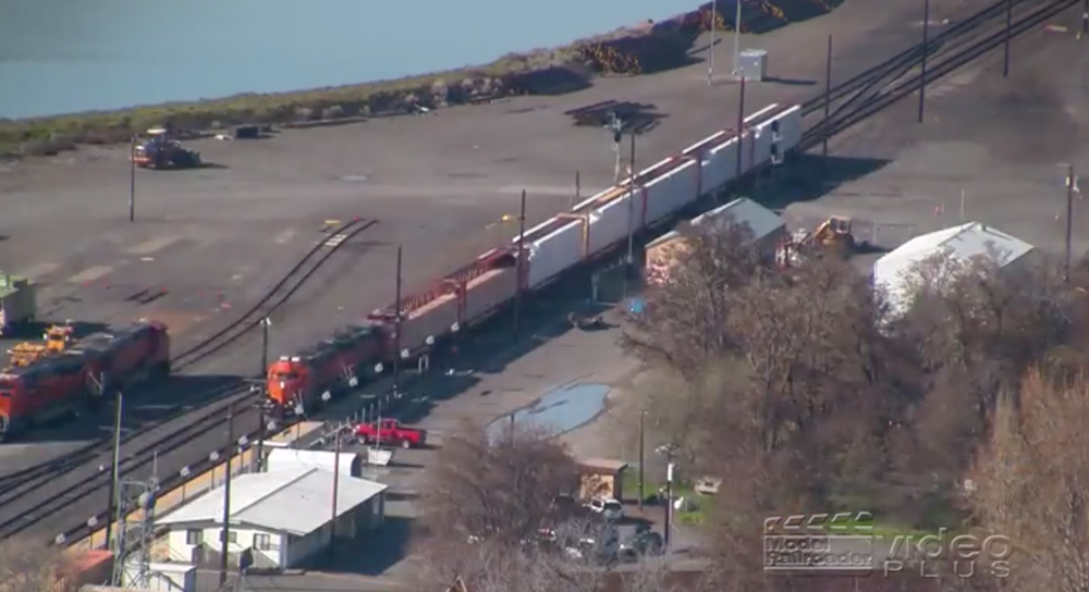 A distant train as seen from a high vantage point in full sunshine.