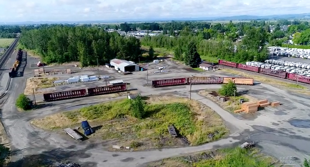 An bird's eye-view of a rail yard and logging facility.