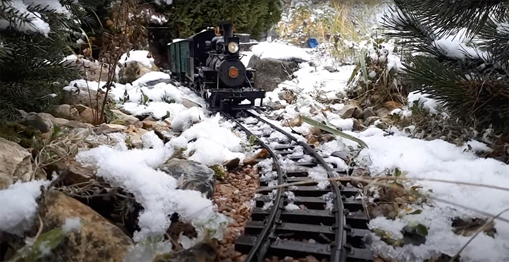 model train on a snowy garden railway