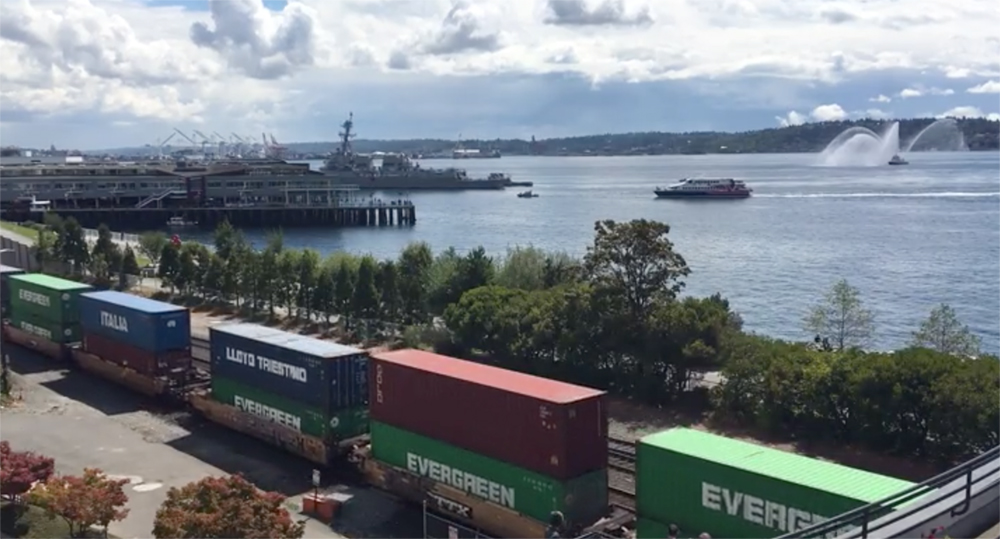 View from an office building overlooking railroad tracks and a freight waterway in the Pacific Northwest.