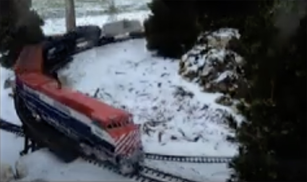 trains running in winter on a garden railroad