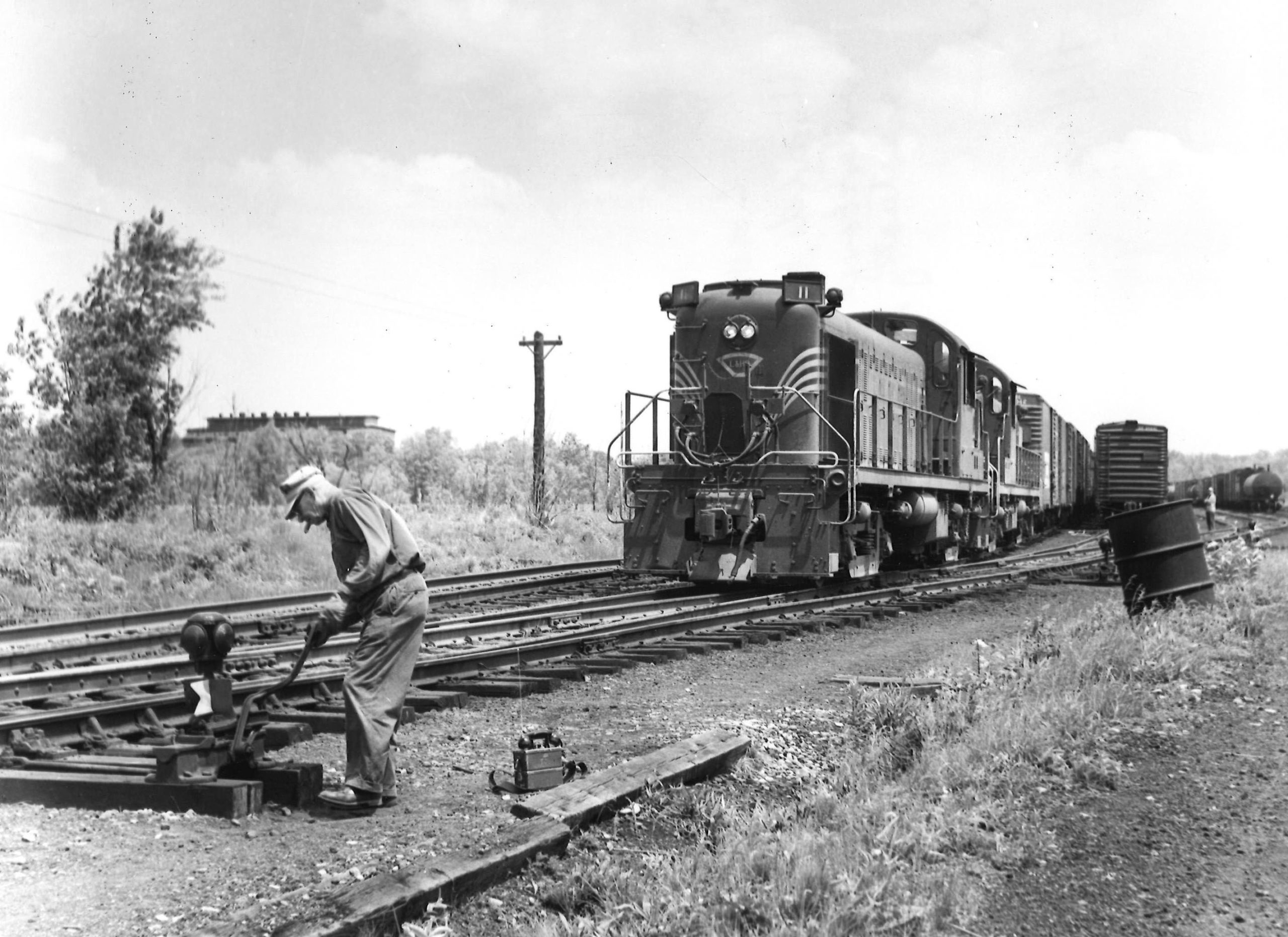 Worker throwing switch for freight train