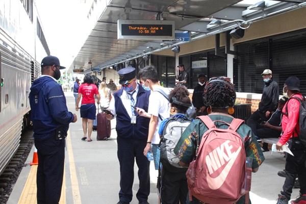 passenger train conductor scanning tickets