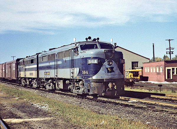 Two blue diesel cab locomotives lead a freight train.