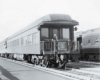 The tail of an observation car in a yard or station displaying an "Empire Builder" emblem on the rear.