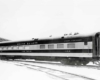 Angled side view of a passenger car in a rail yard.