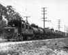 An electric freight motor hauling tank cars.