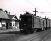 A box motor hauls a one-car freight train.