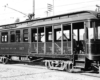 A side-long image of a half-open, half-enclosed electric interurban car.