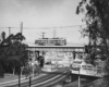 A PCC-style streetcar crosses a bridge over a highway.
