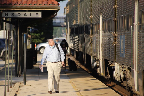 Man walks down platform after getting off commuter train