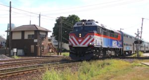 Passenger train passes brick interlocking tower