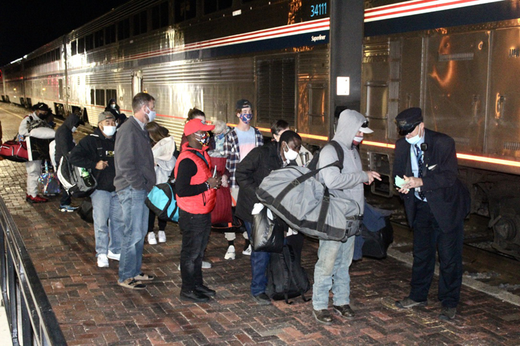 Masked people wait for train