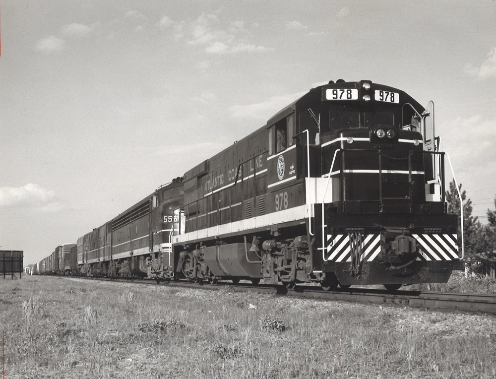 Oblique front view of a diesel locomotive leading a freight train.