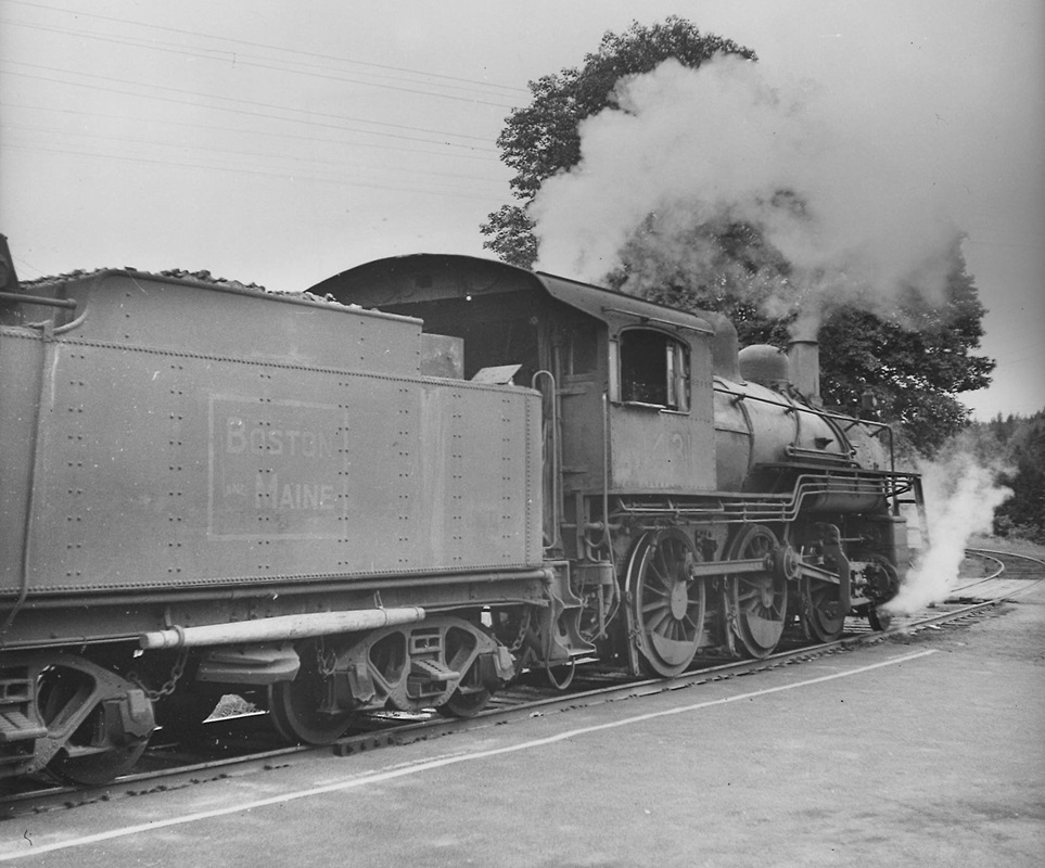 An oblique rear view of a 2-6-0 steam locomotive and most of its tender.