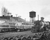 One each of diesel, electric, and steam locomotives pose beside each other in a rail yard.