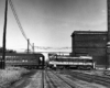 Diesel locomotive hauling empty passenger cars pauses on a double-diamond.