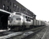 A cab diesel locomotive at the head of a express and passenger-car train.