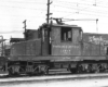 A steeple cab freight motor paused in a yard.