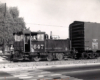 A small gas-powered locomotive hauls a boxcar.