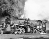 Side view of a 2-8-8-2 steam locomotive with a large smoke plume.