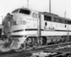 Oblique front view of a cab style diesel locomotive in a rail yard.