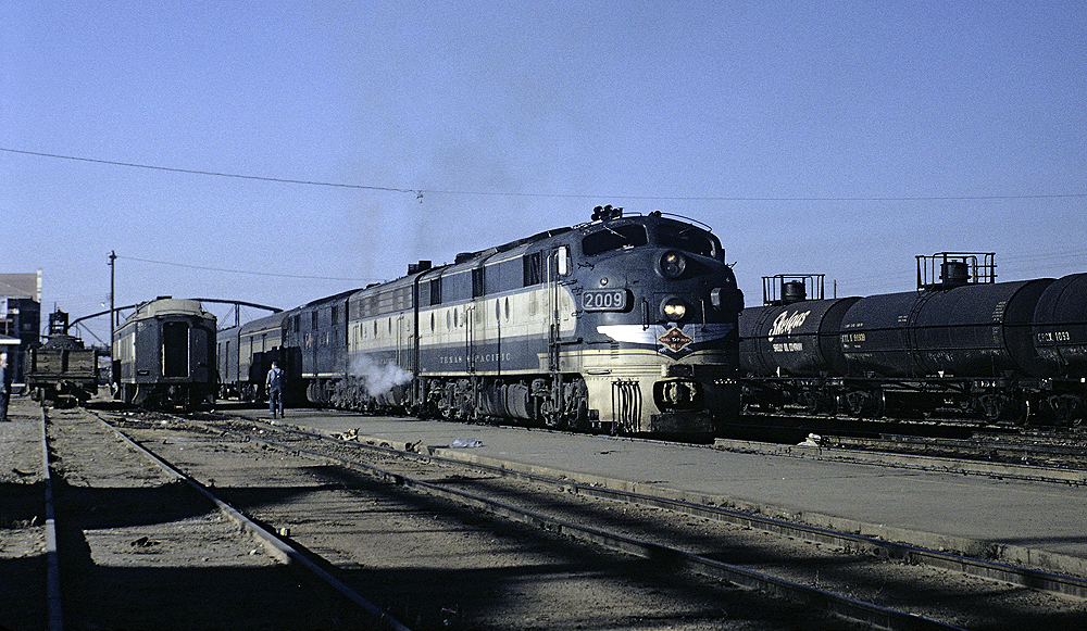 Blue and yellow painted diesel locomotives hauling a train.