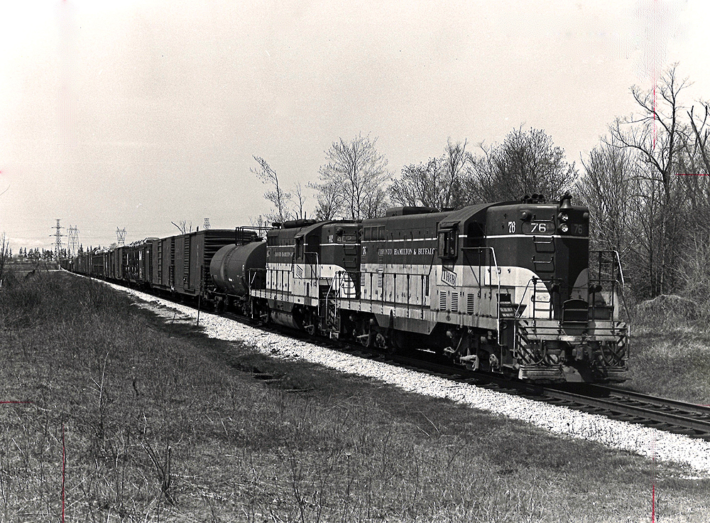 Three Toronto, Hamilton & Buffalo diesel locomotives with freight train.