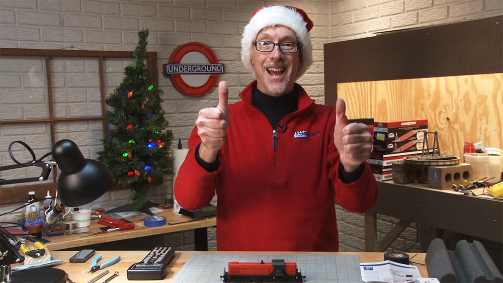 David Popp standing at his basement workbench wearing a santa hat